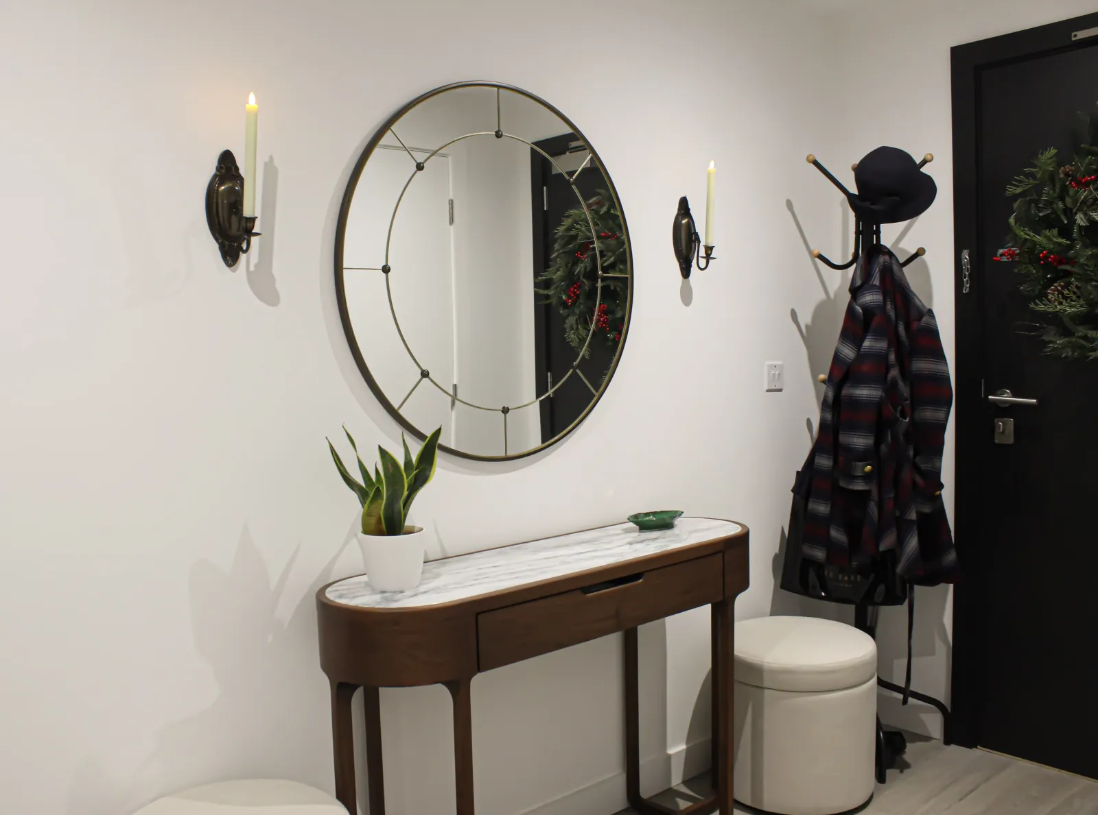 A Parisian inspired entryway with walbut console and antique brass mirror with wall sconces.